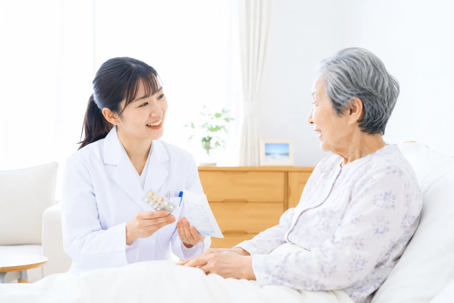 在宅医療で薬を説明する薬剤師